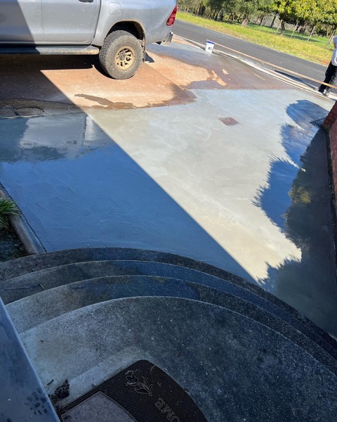 A freshly poured concrete slab beside a pond by TJC Building