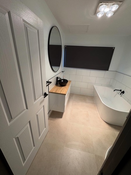 A renovated bathroom with a freestanding basin by TJC Building