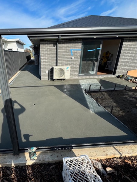 A concrete slab poured beside a home by TJC Building
