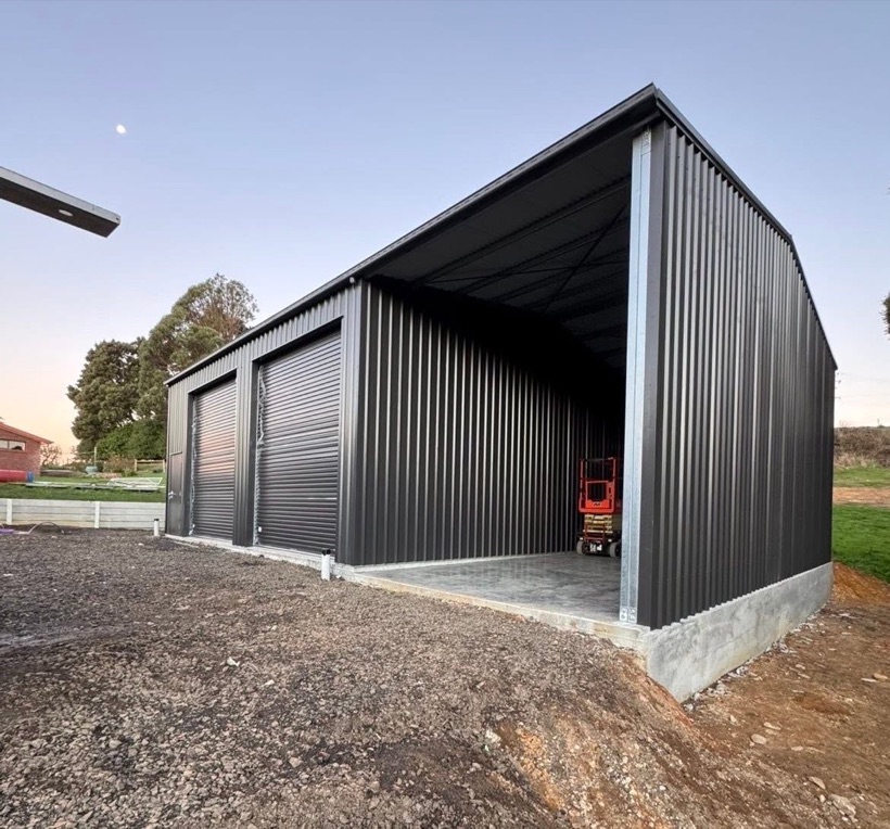 A steel shed with an open bay erected by TJC Building at dusk