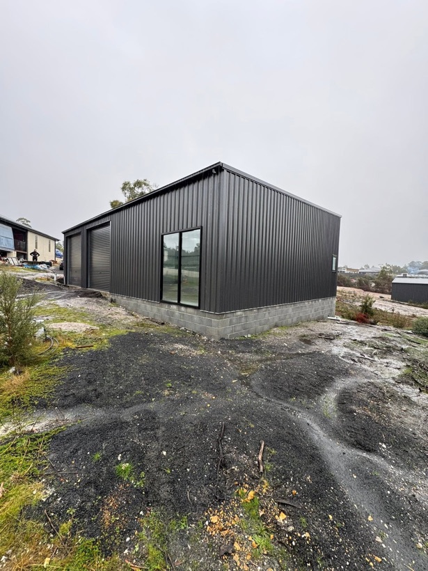 A charcoal steel shed with roller doors erected by TJC Building