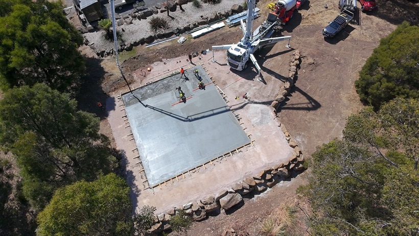 An exposed aggregate courtyard laid between a home and shed by TJC Building